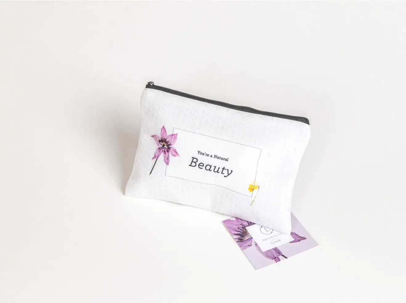 White pouch with floral design and text on a white background